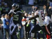 Seattle Seahawks cornerback Richard Sherman (25) carries the ball during a 64-yard punt-return run as Chicago Bears linebacker Lamin Barrow, right, pursues in the first half of an NFL football game, Sunday, Sept.