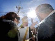 Cardinal Sean O'Malley blesses a family after mass Tuesday along the international border wall in Nogales, Ariz.