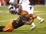 Washington's Dwayne Washington is tackled by Oklahoma State's Ryan Simmons during the Cactus Bowl on Friday, Jan. 2, 2015, in Tempe, Ariz.