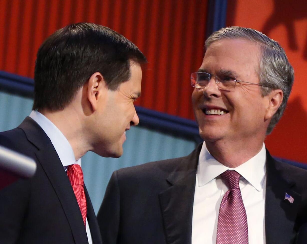 Republican presidential candidates Marco Rubio, left, and Jeb Bush talk during a break during the first Republican presidential debate in August at the Quicken Loans Arena in Cleveland.