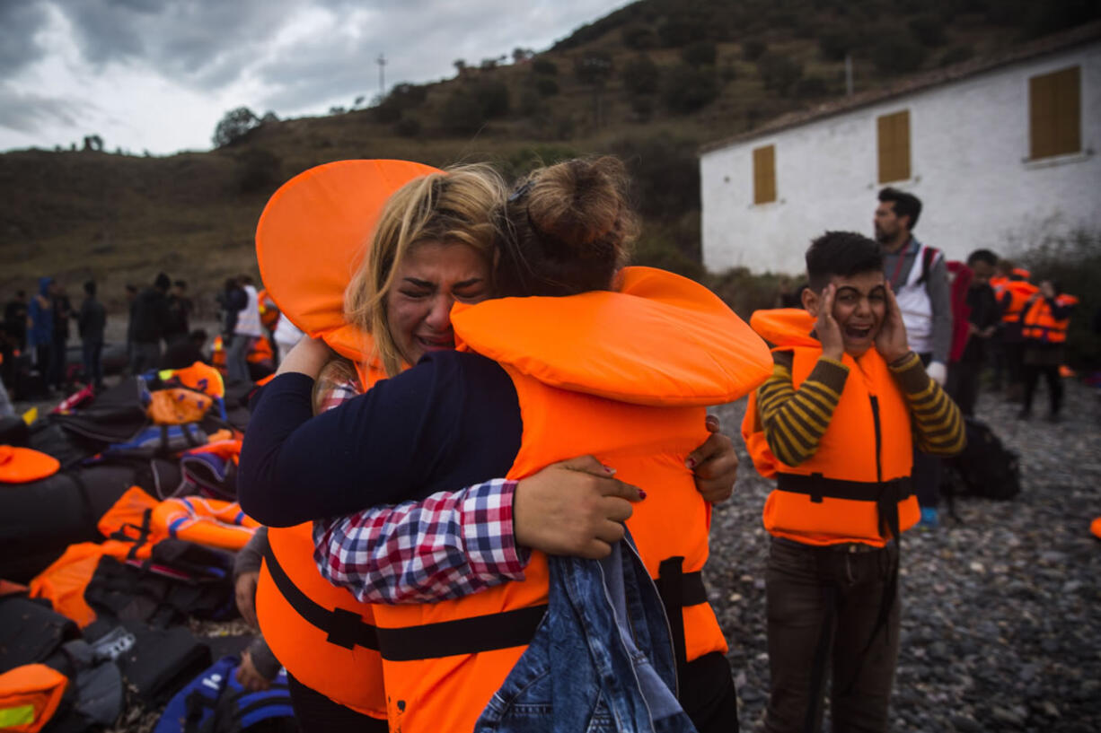 Two women hug each other as a boy cries after their arrival Thursday from Turkey to the Greek island of Lesbos.