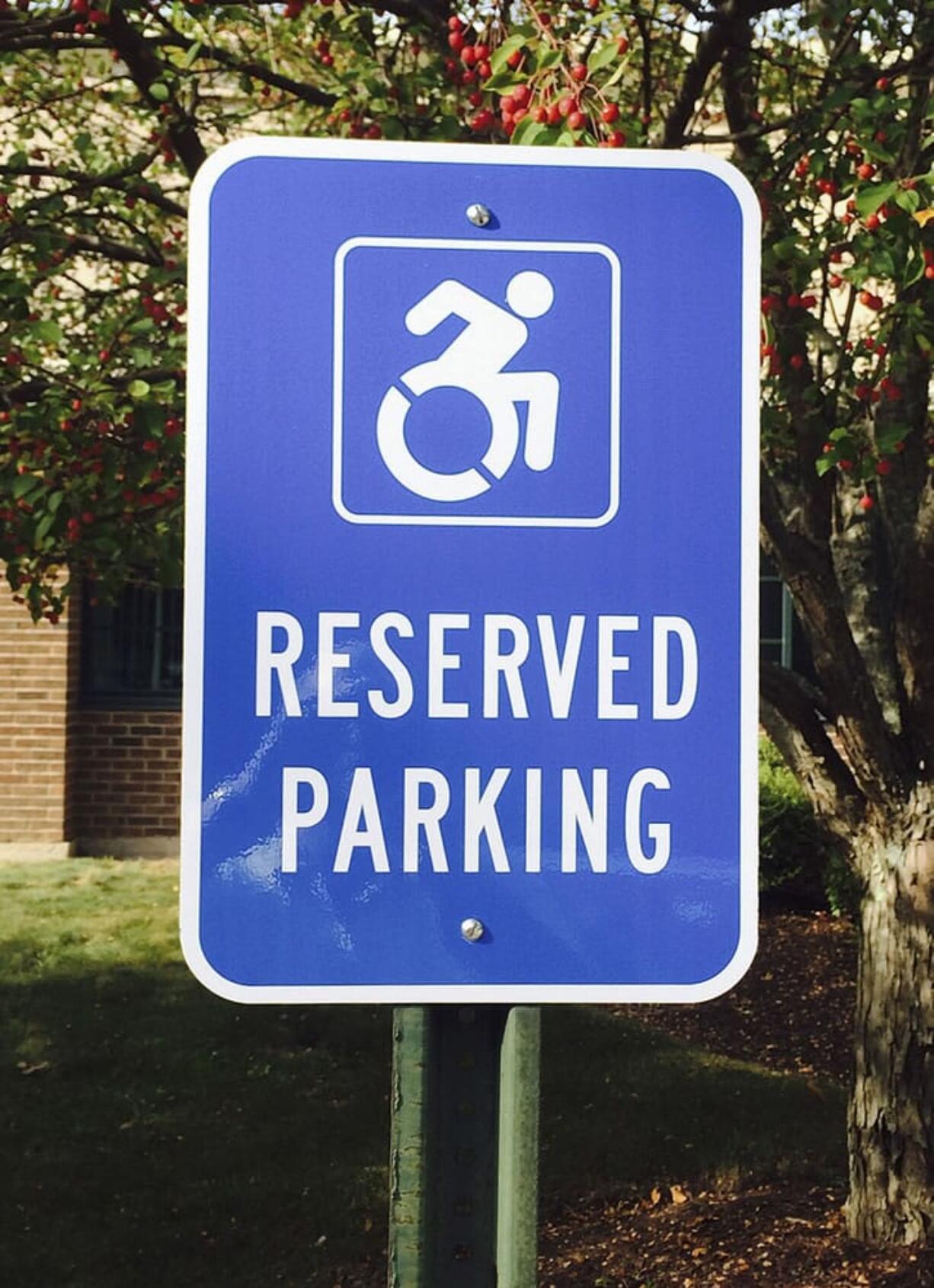 A modernized handicapped sign designates a reserved space in a parking lot in Canton, Conn. Advocates want to replace the familiar image of a stick figure in a wheelchair with the action-oriented logo to emphasize ability, not disability.