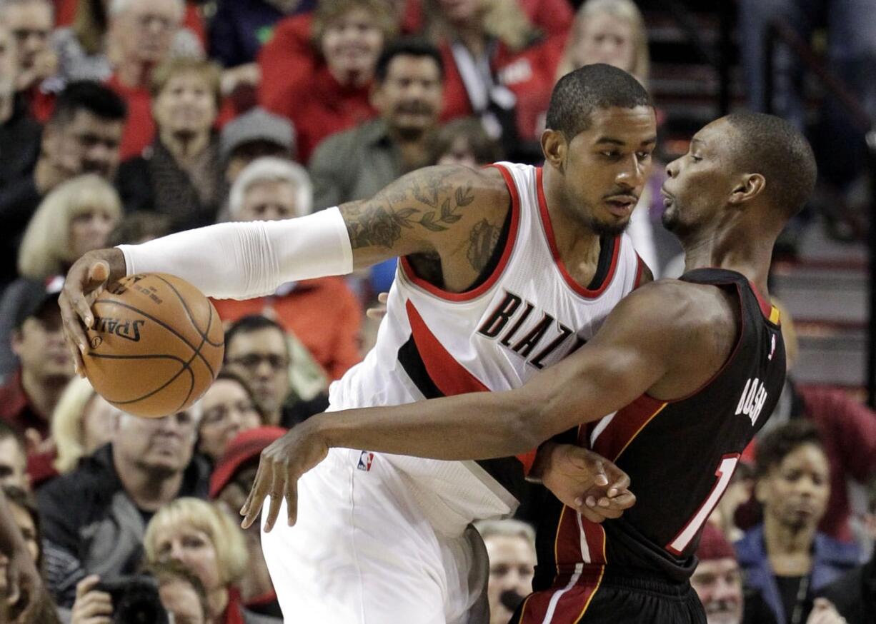 Portland Trail Blazers forward LaMarcus Aldridge, left, drives against Miami Heat center Chris Bosh during the first half in Portland on Thursday, Jan. 8, 2015.