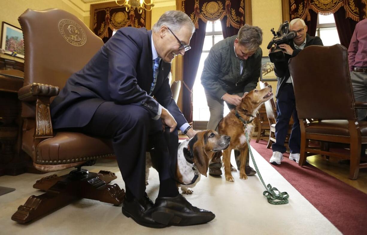 B.J. Duft, second from left, of Vashon Island holds his dogs Tillie, right, and Phoebe, as they visit with Washington Gov. Jay Inslee, left, on Thursday in his office in Olympia. (AP Photo/Ted S.