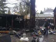 Allen Machia looks at the damage that was caused Sunday morning when a fire broke out in a shed next to his home. The fire spread to the outside of the house.