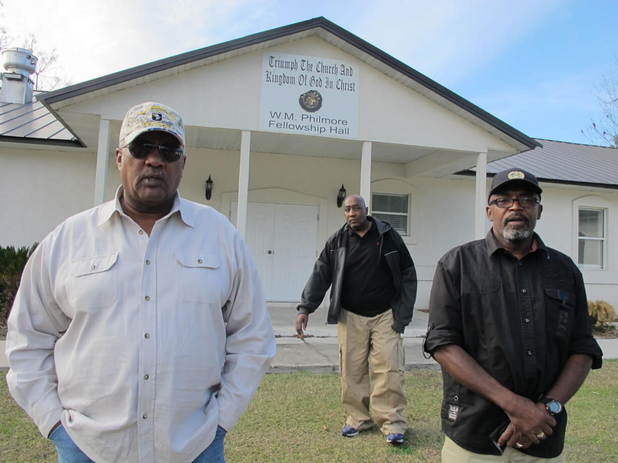 Alonzo Philmore, left, Harry Campbell, center, and Suwannee County NAACP president Leslie White stand in front of their church last month in Live Oak, Fla.  In 1952 a wealthy black woman named Ruby McCollum was found guilty by an all-male, white jury for the murder of a prominent white doctor and state senator-elect, Clifford Leroy Adams.