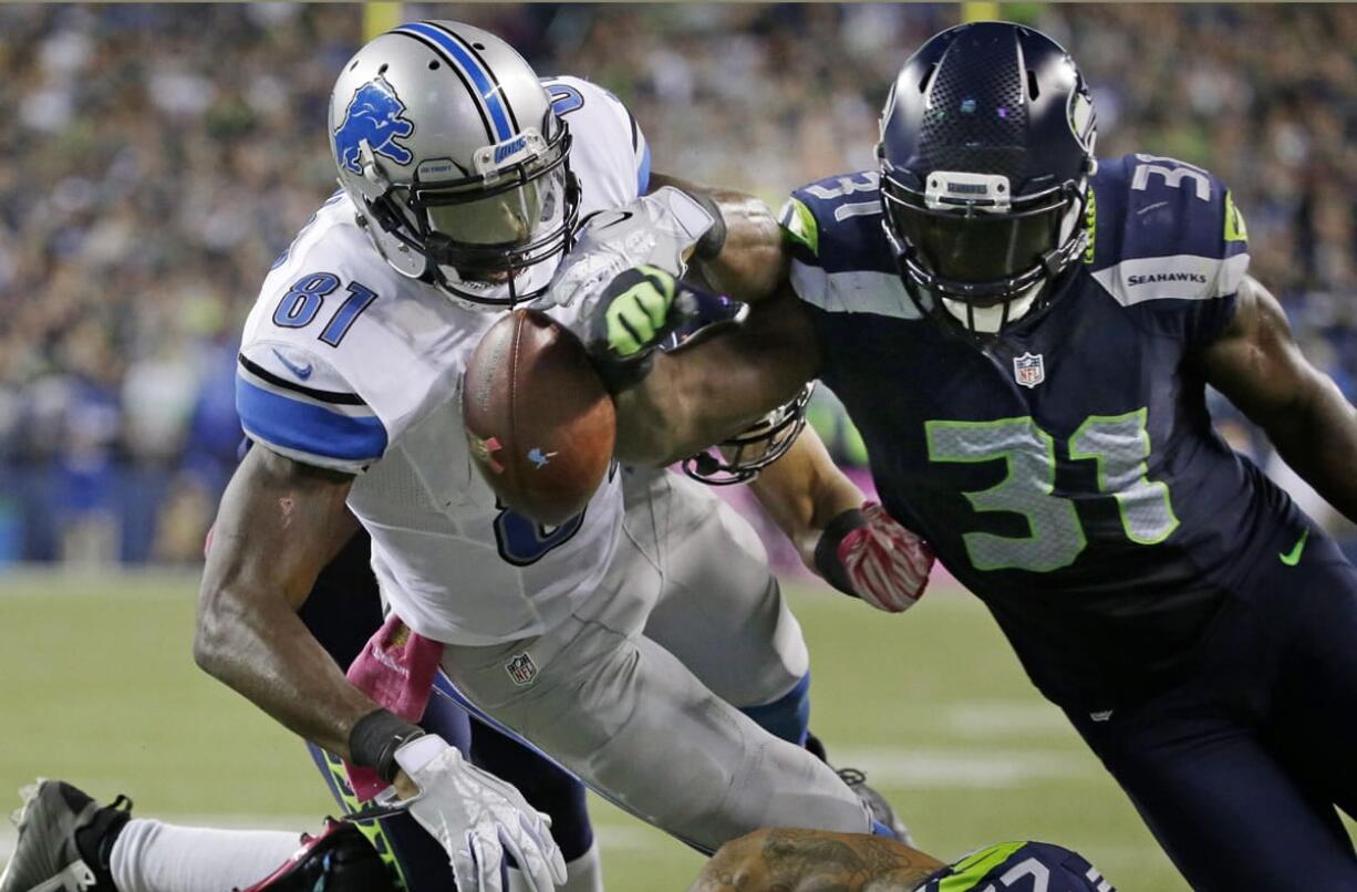 Detroit Lions wide receiver Calvin Johnson (81) has the ball knocked loose by Seattle Seahawks strong safety Kam Chancellor (31) in the closing minutes of the fourth quarter, Monday, Oct. 5, 2015, in Seattle. The fumble went out of bounds in the end zone and was ruled a touchback. The Seahawks beat the Lions 13-10.