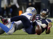 Seattle Seahawks quarterback Russell Wilson, right, spent several plays during Monday&#039;s game on his back or running to elude Detroit Lions defenders.