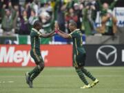 Portland Timbers midfielder Diego Chara, left, celebrates with teammate Darlington Nagbe, right, after Nagbe scored a goal in a game against the Colorado Rapids during the first half of their MLS soccer game in Portland, Ore., Sunday, Oct. 25, 2015.