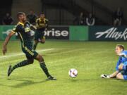 Sporting KC goalkeeper Tim Melia (29) goes after a ball as Portland Timbers forward Fanendo Adi (9) closes in during the first half of a knockout round MLS playoff soccer match in Portland, Ore. on Thursday, Oct. 29, 2015.