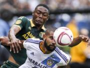 Los Angeles Galaxy defender Leonardo (22) and Portland Timbers forward Fanendo Adi (9) fight for a ball in the their MLS soccer game in Carson, Calif., Sunday, Oct. 18, 2015. Timbers won 5-2. (AP Photo/Ringo H.W.