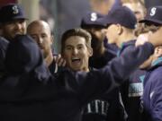 Seattle Mariners' Brad Miller, center, celebrates his two-run home run against the Los Angeles Angels during the ninth inning of a baseball game on Tuesday, April 1, 2014, in Anaheim, Calif. (AP Photo/Jae C.