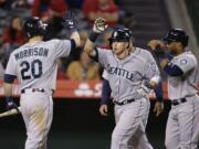 Seattle's Justin Smoak, center, celebrates his three-run home run with Logan Morrison, left, and Robinson Cano, right, during the ninth inning Monday.