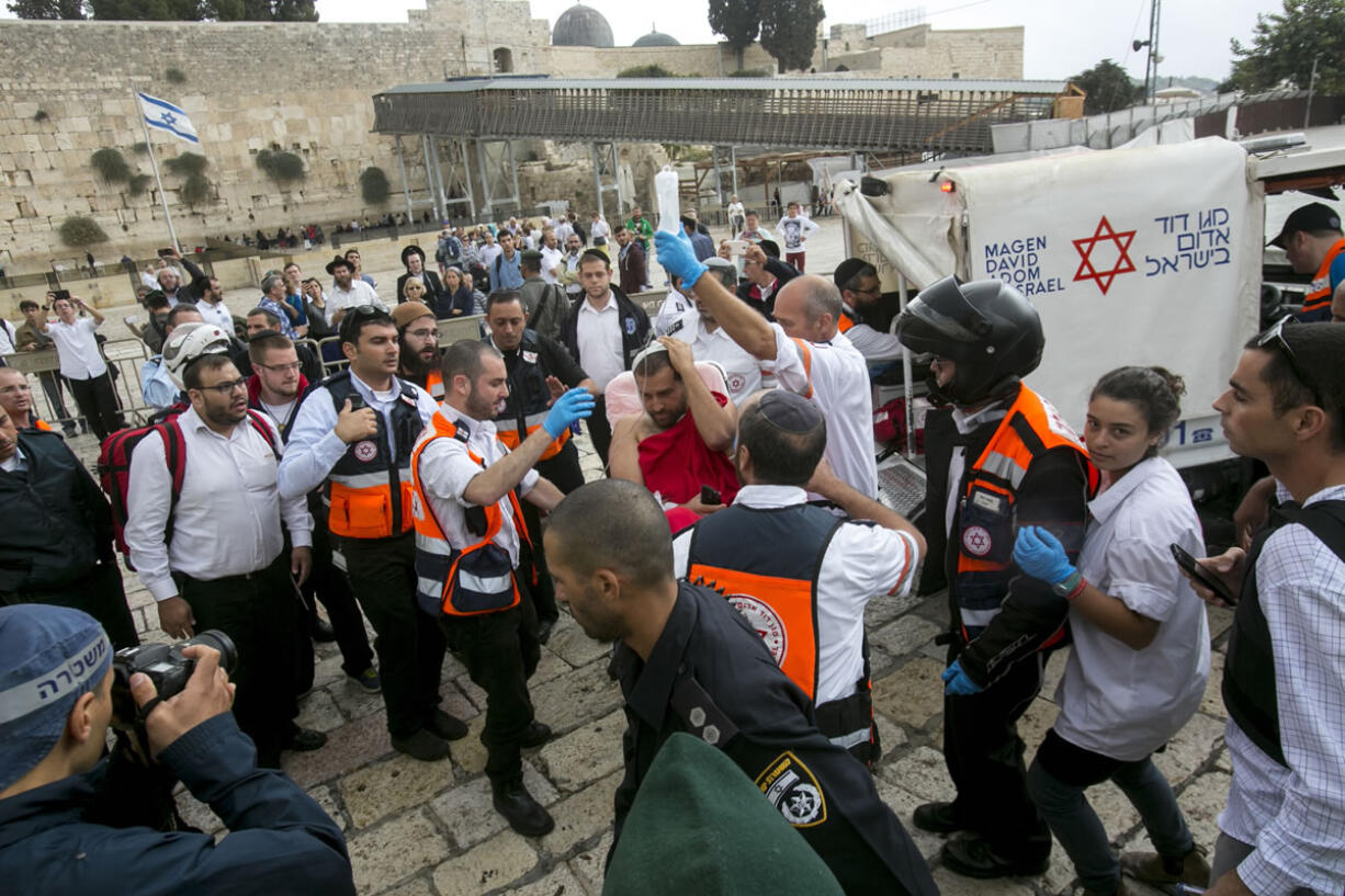 With the Western Wall in the background, Israeli medics evacuate a wounded man following a stabbing attack Wednesday in Jerusalem&#039;s Old City.