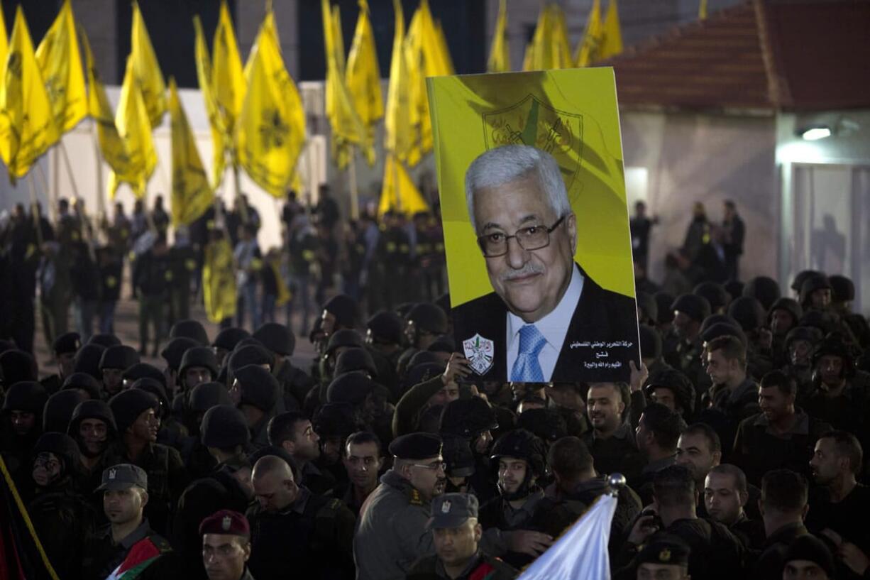 MAJDI MOJAMMED/Associated Press
Palestinians hold up a poster showing President Mahmoud Abbas on Wednesday as they celebrate the 50th anniversary of the Fatah movement in the West Bank city of Ramallah.