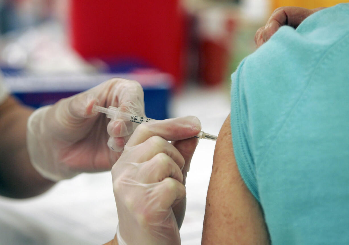 A customer gets the seasonal flu vaccine at a Walgreens.