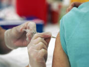 A customer gets the seasonal flu vaccine at a Walgreens.