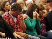 Mathew Downing, who attended Skyview High School in Vancouver, from left, Lacey Scroggins and Lisa Scroggins wipe their eyes during a church service at the New Beginnings Church of God on Sunday in Roseburg, Ore. Mathew Downing and Lacey Scroggins are survivors of the shooting at Umpqua Community College.