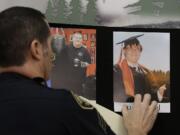 Portland Police Sgt. Pete Simpson places a photo of shooting victim Lucas Eibel, 18, next to a photo of victim Quinn Cooper, 18, for during a news conference, Friday in Roseburg, Ore.