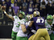 Oregon quarterback Vernon Adams Jr., left, passes around his blockers in the first half of an NCAA college football game against Washington, Saturday, Oct. 17, 2015, in Seattle. (AP Photo/Ted S.