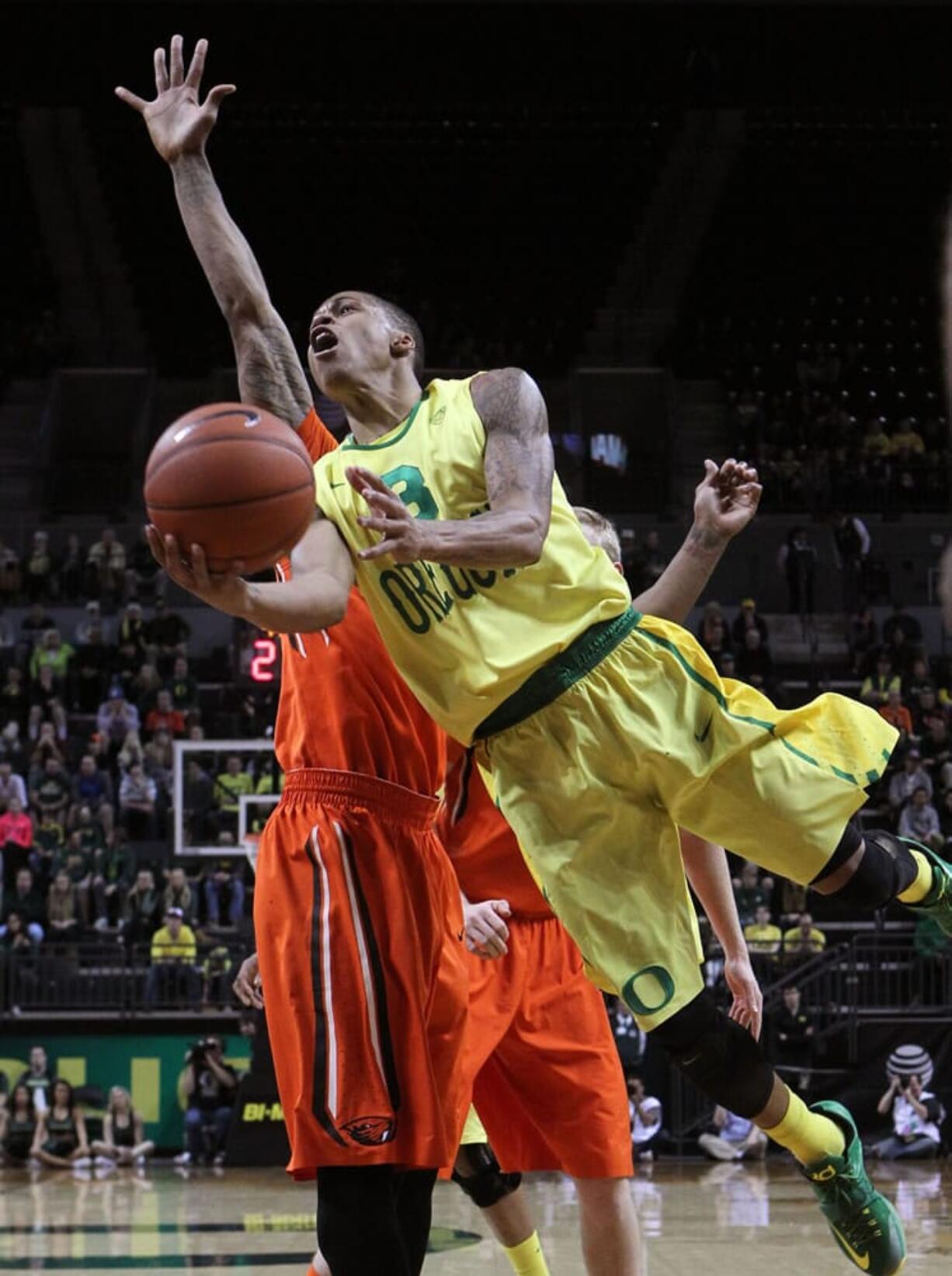 Oregon's Joseph Young shoots around Oregon State's Gary Payton II during the second half in Eugene, Ore., Saturday, Jan. 3, 2015.