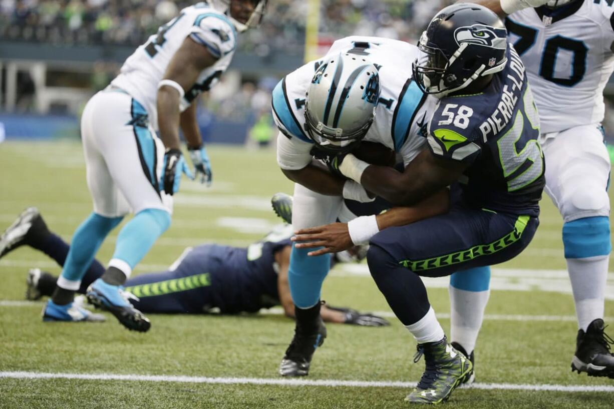 Carolina Panthers quarterback Cam Newton, center, rushes for a touchdown past Seattle Seahawks linebacker Kevin Pierre-Louis (58) in the first half of an NFL football game against the Seattle Seahawks, Sunday, Oct. 18, 2015, in Seattle.