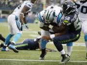 Carolina Panthers quarterback Cam Newton, center, rushes for a touchdown past Seattle Seahawks linebacker Kevin Pierre-Louis (58) in the first half of an NFL football game against the Seattle Seahawks, Sunday, Oct. 18, 2015, in Seattle.