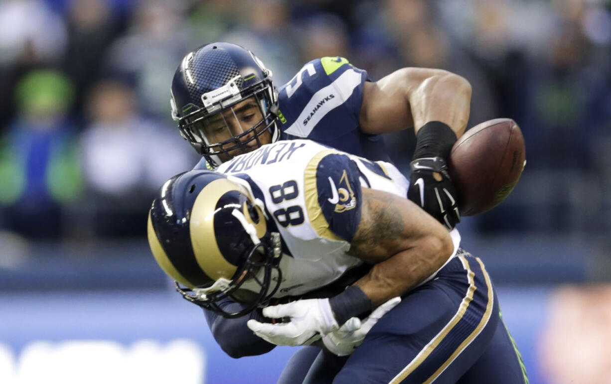 Associated Press files
Seattle linebacker Bobby Wagner, right, strips the ball from St. Louis tight end Lance Kendricks (88) during a Dec. 28 game. The play was an example of the ferocity that Wagner and Carolina's Luke Kuechly are known for, a playing style that clashes with their personalities off the field. The teams play Saturday in Seattle.