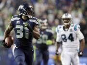 Seattle Seahawks strong safety Kam Chancellor (31) runs in front of Carolina Panthers tight end Ed Dickson (84) to score on a 90-yard interception return in the fourth quarter Saturday in the NFL divisional playoff game in Seattle, Saturday, Jan. 10, 2015.