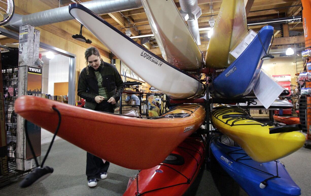 A customer looks over sea kayaks as she shops at Recreational Equipment, Inc. store in Seattle.