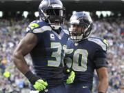 Seattle Seahawks' Kam Chancellor, left, and K.J. Wright, right, celebrate a play against the St. Louis Rams in the second half of an NFL football game, Sunday, Dec.