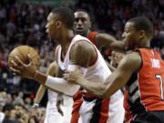 Portland Trail Blazers guard Damian Lillard, left, is fouled from behind by Toronto Raptors guard Kyle Lowry during overtime of an NBA basketball game in Portland, Ore., Tuesday, Dec. 30, 2014. Lillard led the Trail Blazers in scoring with 26 ponts as they beat the Raptors in overtime 102-97.