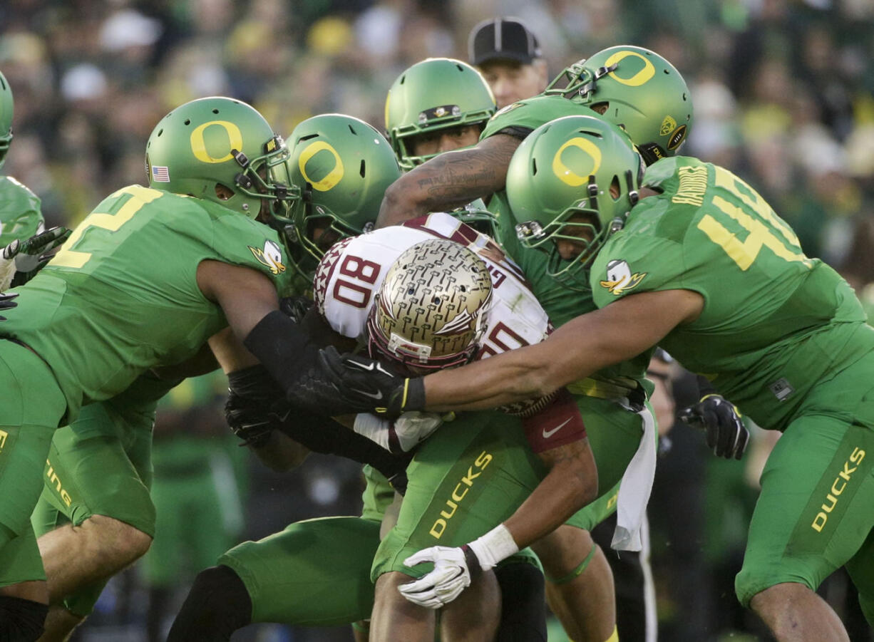 Florida State wide receiver Rashad Greene gets tackled by Oregon defenders during the second half of the Rose Bowl playoff semifinal, Thursday, Jan. 1, 2015 in Pasadena, Calif. (AP Photo/Jae C.