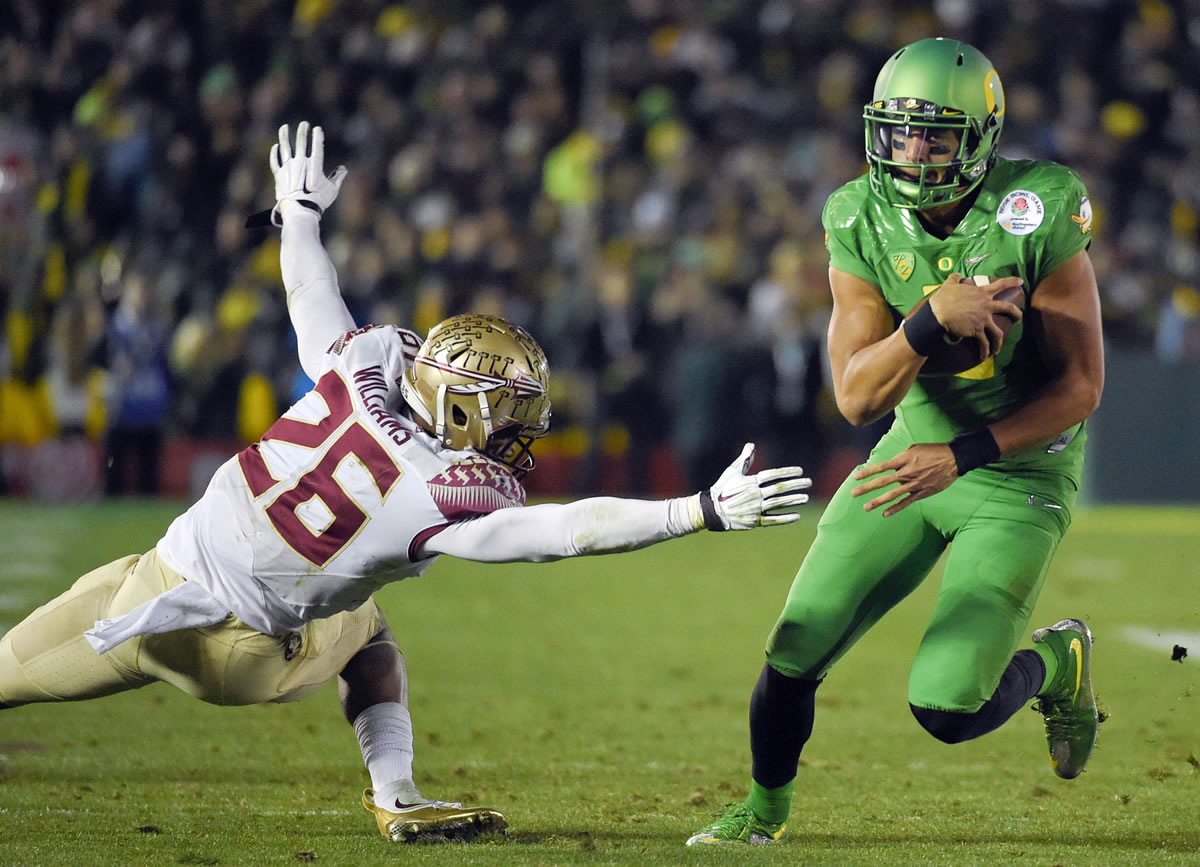 Oregon quarterback Marcus Mariota, right, scores past Florida State defensive back P.J. Williams during the fourth quarter of the Rose Bowl on Thursday, Jan. 1, 2015, in Pasadena, Calif. (AP Photo/Mark J.