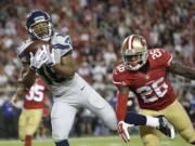 Seattle Seahawks wide receiver Tyler Lockett (16) catches a 43-yard touchdown in front of San Francisco 49ers cornerback Tramaine Brock (26) during the first half of an NFL football game in Santa Clara, Calif., Thursday, Oct. 22, 2015.