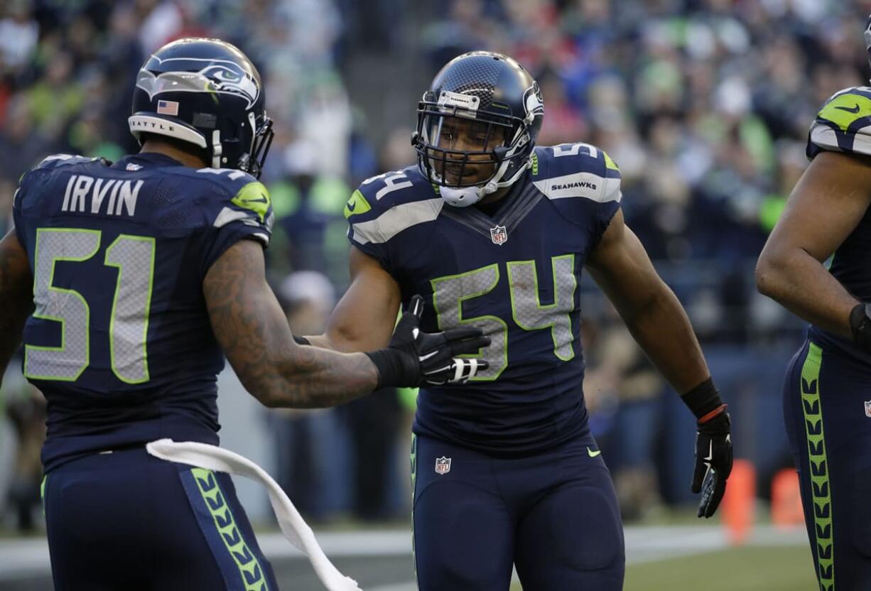 Seattle Seahawks middle linebacker Bobby Wagner (54) and outside linebacker Bruce Irvin (51) react to a play against the San Francisco 49ers in the second half Sunday, Dec. 14, 2014, in Seattle.