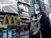 Cristina Gutierrez, center, takes a picture Thursday of herself, her brother, Hector Gutierrez Jr., right, and her father, Hector Gutierrez Sr., using a selfie stick in Times Square in New York.