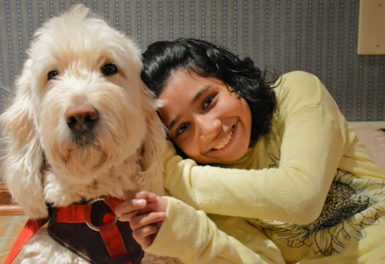 Ehlena Fry poses with her service dog, Wonder, at their home in Manchester, Mich., on Friday. The U.S. Supreme Court is being asked to take an appeal from Ehlena Fry, with cerebral palsy who switched schools after her service dog wasn't welcomed in a district in Jackson County.