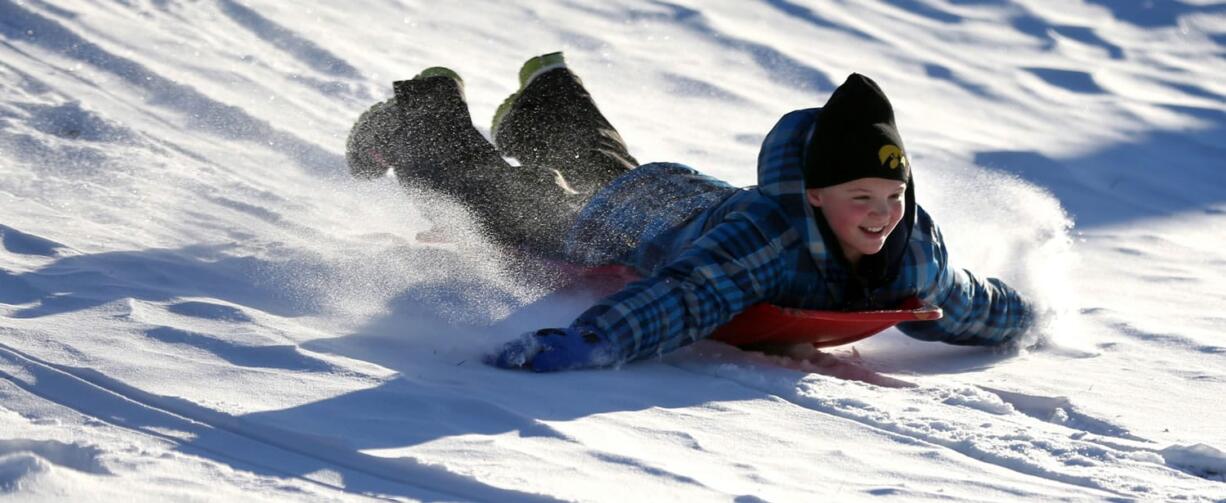 Associated Press files
Zoe Reisen,10, sleds down a hill Dec. 11, 2013, at Allison-Henderson Park on in Dubuque, Iowa. Faced with the potential bills from people who are injured sledding, Dubuque is one of the cities across the country that is opting to close hills rather than face the risk of large liability claims.