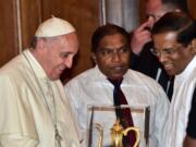 Pope Francis exchanges gifts with newly elected Sri Lankan President Maithripala Sirisena, right, in the Presidential Secretary's office in Colombo, Sri Lanka, on Tuesday.