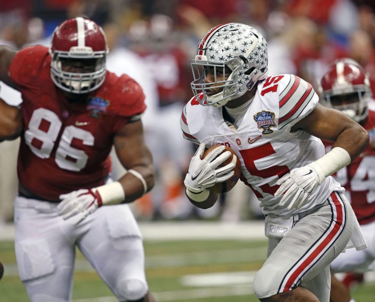 Ohio State running back Ezekiel Elliott (15) runs 85 yards toward the end zone as Alabama defensive lineman A'Shawn Robinson (86) looks on in the fourth quarter of the Sugar Bowl on Thursday, Jan. 1, 2015, in New Orleans. Elliott scored a touchdown on the play.