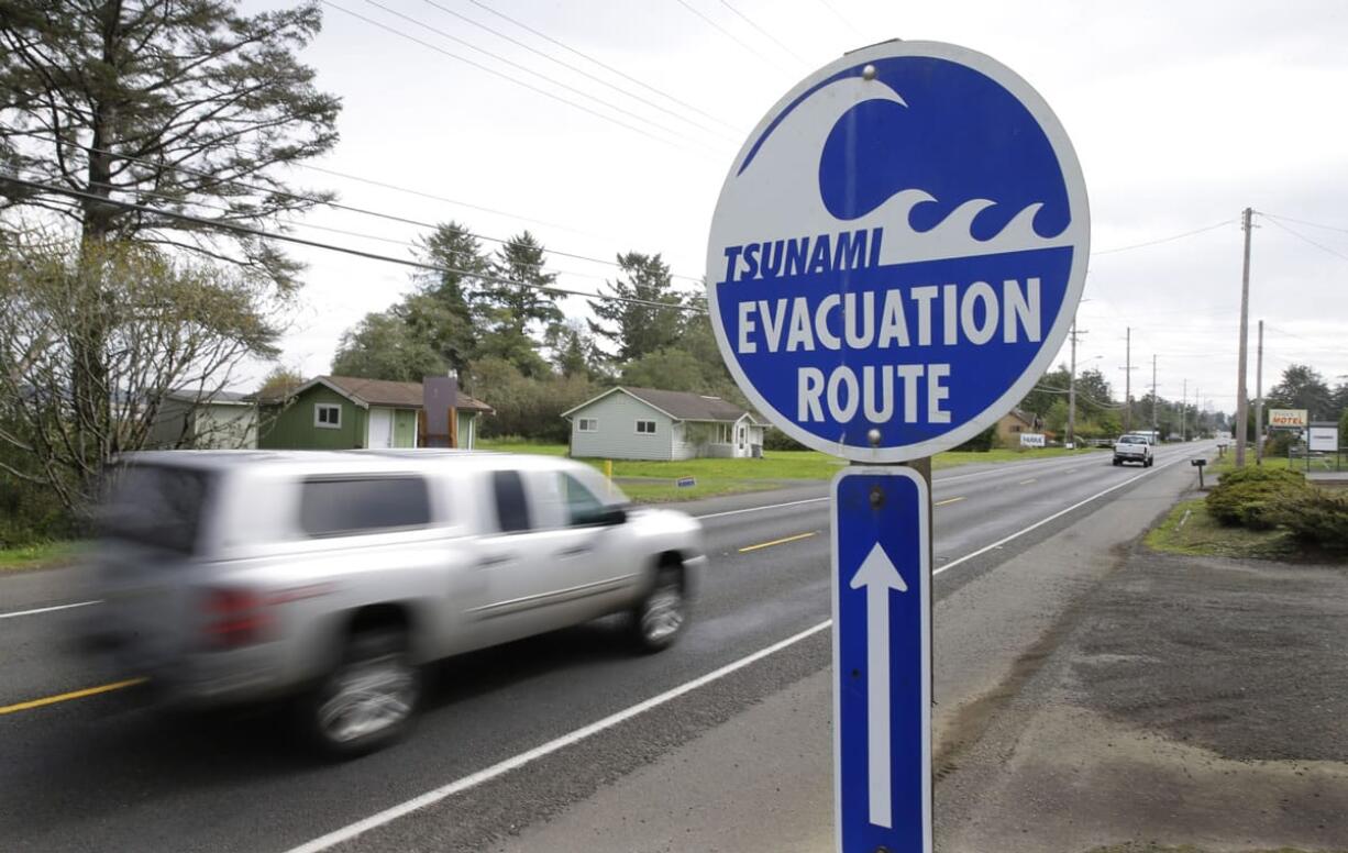 A sign designates a tsunami evacuation route earlier this month in Westport. A new elementary school being built in the town will serve a second role as a tsunami shelter, because Westport currently has no ground high enough to protect people from the high waters and debris that could come from an earthquake-generated tsunami. (Ted S.