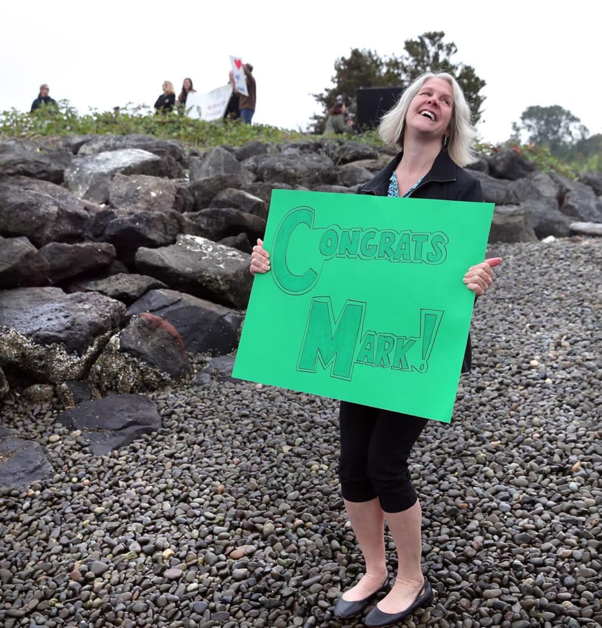 Elinor Fanning holds a sign for her husband, Mark Powell, of Bainbridge Island as he finishes the last leg of his Swim Duwamish project Wednesday in Seattle.