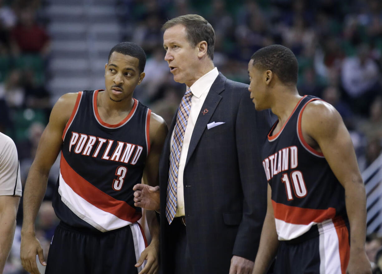 Portland Trail Blazers head coach Terry Stotts, center, speaks with C.J. McCollum (3) and Tim Frazier (10) during the second quarter of an NBA preseason basketball game against the Utah Jazz Monday, Oct. 12, 2015, in Salt Lake City.