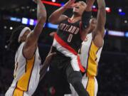 Portland Trail Blazers guard Damian Lillard, center, goes up for a shot as Los Angeles Lakers center Jordan Hill, left, and forward Ed Davis defend during the second half Sunday, Jan. 11, 2015, in Los Angeles. The Blazers won 106-94. (AP Photo/Mark J.