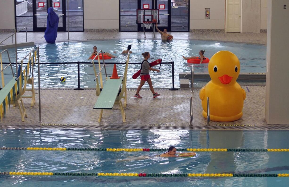 University of Oregon students swim Monday in the new 12-lane lap pool, foreground, and play in the recreational pool at the Student Recreation Center on the campus in Eugene, Ore.