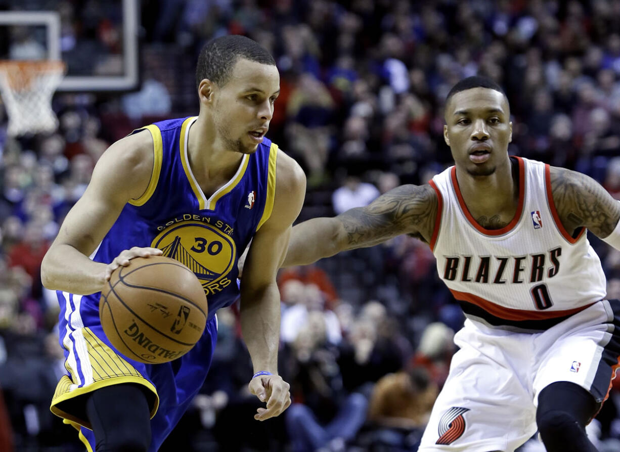 Golden State Warriors guard Stephen Curry, left, drives past Portland Trail Blazers guard Damian Lillard during the first half Sunday.