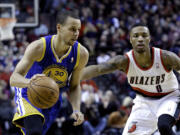 Golden State Warriors guard Stephen Curry, left, drives past Portland Trail Blazers guard Damian Lillard during the first half Sunday.