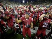 The Washington State football team celebrates after beating Oregon in double overtime 45-38 on Saturday, Oct. 10, 2015, in Eugene, Ore.