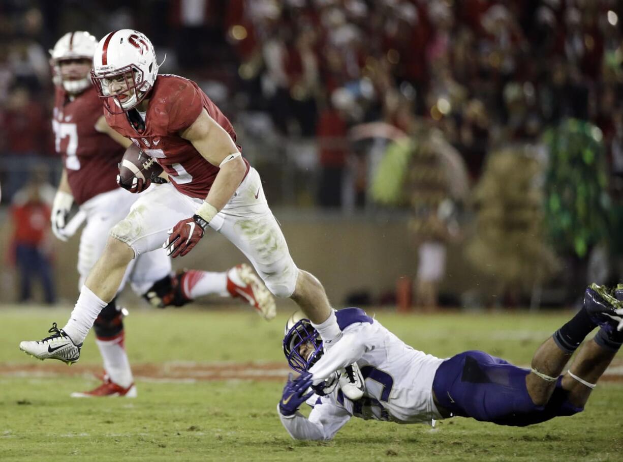 Stanford running back Christian McCaffrey (5) leaps over Washington defensive back Brian Clay (35) during the second half Saturday, Oct. 24, 2015, in Stanford, Calif.